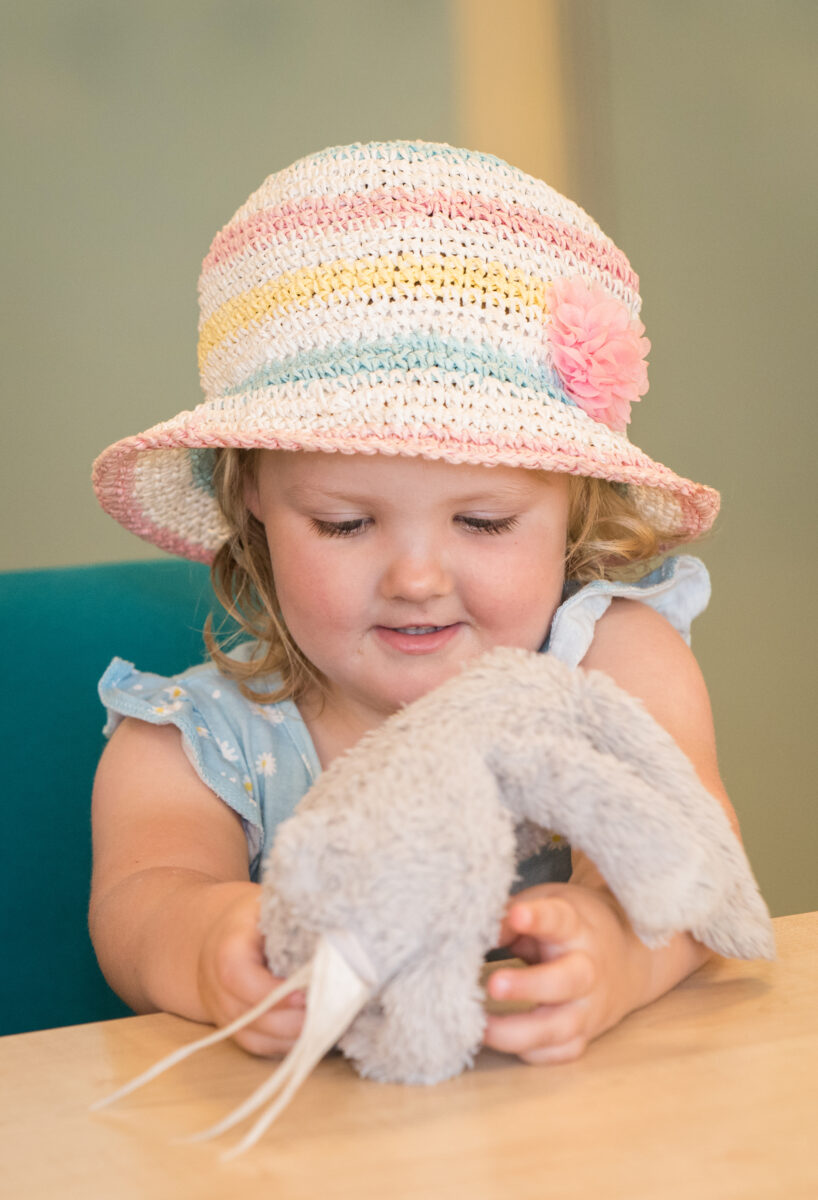 Young girl looking at a soft toy