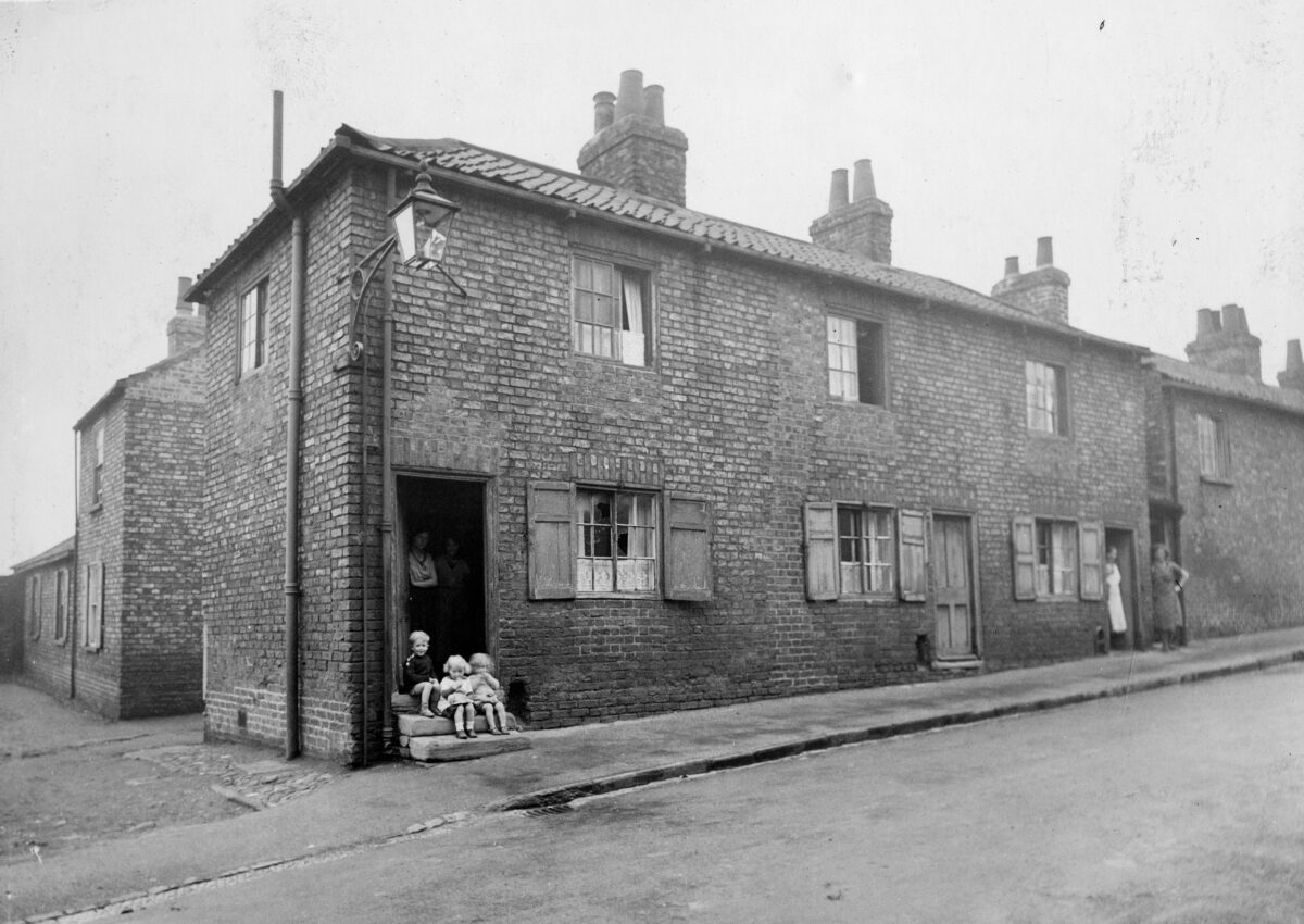 Women and children in the doorways of terrraced housing