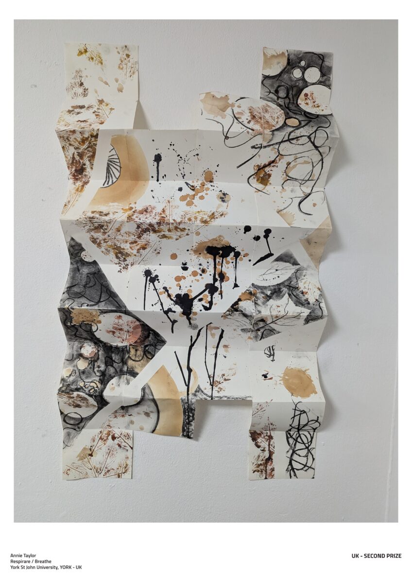 A photograph of some artwork. It is folded paper with ink drawings in black and gold.